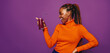Young woman enjoying a fresh and vibrant smoothie on a purple background