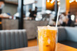 A glass of iced Thai milk tea with a blurry background. Thai tea drink.