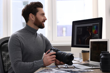 Poster - Professional photographer with digital camera at table in office