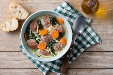 Canvas Print - Italian Wedding Soup with meatballs and spinach on wooden table. Top view