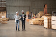 © chokniti - Engineer team standing walking in warehouse examining hardwood material for wood furniture production, Worker check stock, Technician man and woman working on quality control in lumber pallet factory