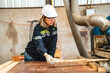 © chokniti - Engineer wearing safety vest controlling industrial machine working, talking with assistant worker checking first for labour with laptop computer, Officer setting a technology system in factory.