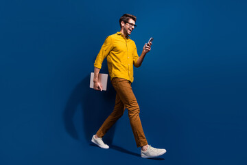 Aufkleber - Full length photo of nice young male walk netbook hold gadget excited wear trendy yellow garment isolated on dark blue color background