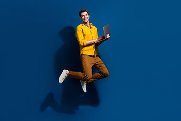 Aufkleber - Full length photo of nice young male jump hold netbook marketer wear trendy yellow garment isolated on dark blue color background