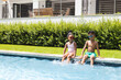 © Wavebreak Media - African American sister and brother sit by a pool, wearing sunglasses, with copy space
