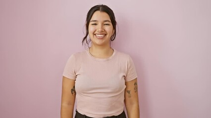 Canvas Print - Excited young hispanic woman standing confidently, flaunting a cool, happy smile over an isolated pink background. perfect teeth glowing amidst her joy-filled, radiant face