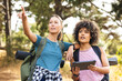 © Wavebreak Media - Young caucasian woman points out direction while hiking with biracial woman holding  tablet