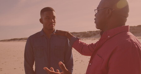 African american man talking to his son at the beach