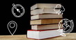 Image of school pictograms floating over books on black background