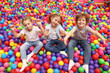 © New Africa - Happy little kids sitting on colorful balls in ball pit