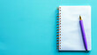© Olga - Top view of notepad with pen lying on blue background