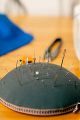 close-up in a sewing workshop pin cushion is completely stuffed with needles and pins