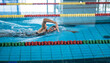 Elite female athlete, professional swimmer during a front crawl swimming workout. Concept of hard training for a competition.