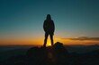 Silhouette of a person achieving the summit at sunset Symbolizing accomplishment