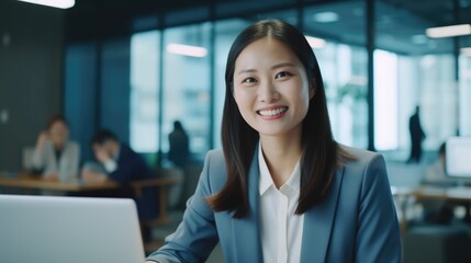 Poster - Woman sitting at a table working on a laptop, suitable for business or technology concepts