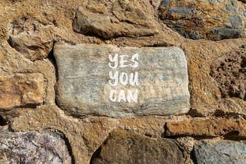 Poster - Motivational and Yes you can symbol. Concept words Yes you can on beautiful big grey stone. Beautiful stone wall background. Business motivational and Yes you can concept. Copy space.