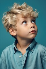 Canvas Print - Young boy in blue shirt looking upwards. Suitable for educational materials