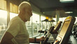 Older white haired man doing exercise in the gym area running on the Treadmill. Active lifestyle for retired people