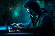 a man in a hoodie typing on a laptop