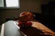 Warm sunlight casts a glow on a banana in a glass bowl on the kitchen counter