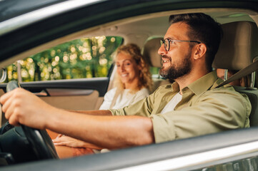 Father driving a car and traveling with his wife and daughters on a weekend trip