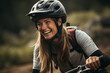 Lachende junge Frau mit Helm beim Mountainbiken, Frau auf Fahrrad beim Downhill