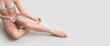 © Pixel-Shot - Beautiful young woman holding soft feathers on grey background with space for text. Epilation concept