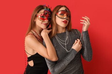 Sticker - Pretty young women in carnival masks on red background