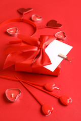 Wall Mural - Composition with gift box, blank card and candles for Valentine's Day celebration on red background