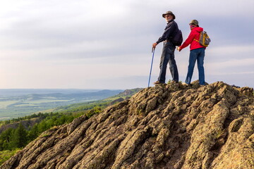 happy mature married couple traveling through the Ural mountains on a summer day