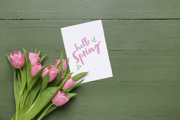 Wall Mural - Greeting card with text HELLO SPRING and beautiful pink tulips on green wooden background