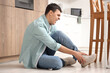 © Pixel-Shot - Young man traumatized his ankle in kitchen