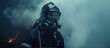 A firefighter, wearing a gas mask and uniform, stands in front of a raging fire, poised to battle the flames with fire hoses. The intense heat and smoke create a dangerous environment for the