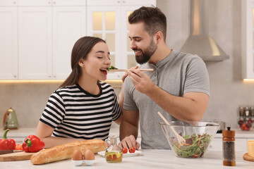 Wall Mural - Lovely young couple cooking together in kitchen