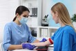 © New Africa - Laboratory testing. Doctor taking blood sample from patient at white table in hospital