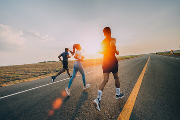 three runners is running on the road at outdoors , healthy lifestyle and sport concepts.