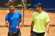 © Katie/peopleimages.com - Men, player and competition on tennis court, athlete and ball or equipment for professional match. Fitness, outdoor and happy people in training for tournament and talking of collaboration in game