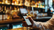Close up of male hands holding a phone and a glass of wine at the bar, restaurant on the dining table