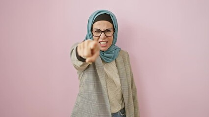 Poster - Middle-aged hispanic woman in hijab, furiously pointing at you, visibly displeased. she's angry, accusing you over pink isolated backdrop