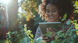 A content woman immersed in her tablet amidst lush green foliage, radiating a relaxed and happy tech-savvy lifestyle.