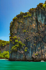 Wall Mural - Aerial panorama of Thailand's verdant, lush tropical island, National Park Island, with blue and aquamarine the sea, and clouds shining by sunlight in the background.