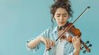 Young beautiful woman playing violin. Attractive girl with closed eyes and curly hair playing violin. Concept of hobby, leisure, art and music.