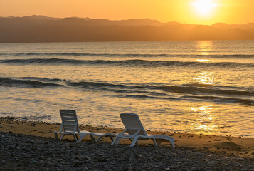 Wall Mural - beach loungers in the setting sun in the evening 8