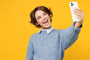 Wall Mural - Young woman wears grey knitted sweater shirt casual clothes doing selfie shot on mobile cell phone post photo on social network isolated on plain yellow background studio portrait. Lifestyle concept.