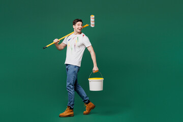 Sticker - Full body young employee handyman man wears white stained t-shirt hold paint roller jar look aside isolated on plain green background. Instruments for renovation apartment room. Repair home concept.