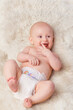© T. Rose/peopleimages.com - Happy baby, diaper and laugh in bedroom, furry blanket and playtime in cute for child development. Infant, kid and wellness for playing, adorable and positive on rug in house for home and toddler fun