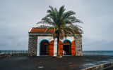 Fototapeta Na ścianę - Porto do Seixal, a natural black sand beach on Madeira island offers breathtaking landscape — the cliffs and mountains of the north coast - and swimming in the crystal-clear water of the volcanic 
