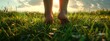 Closeup of female legs walking on green grass in the park. Barefoot walk in lush green grass, symbolizing connection with nature and grounding
