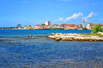 Wall Mural - Scenic view of the Umag old town, Adriatic seacoast, Istria, Croatia. Summer landscape with medieval architecture, clear blue sea water and sky with clouds, outdoor travel background