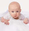 © T. Rose/peopleimages.com - Baby, blue eyes and shock with laying on bed for curiosity, surprise and reaction in bedroom at house. Adorable, child and cute infant with vest in home to observe, relax wonder for knowledge